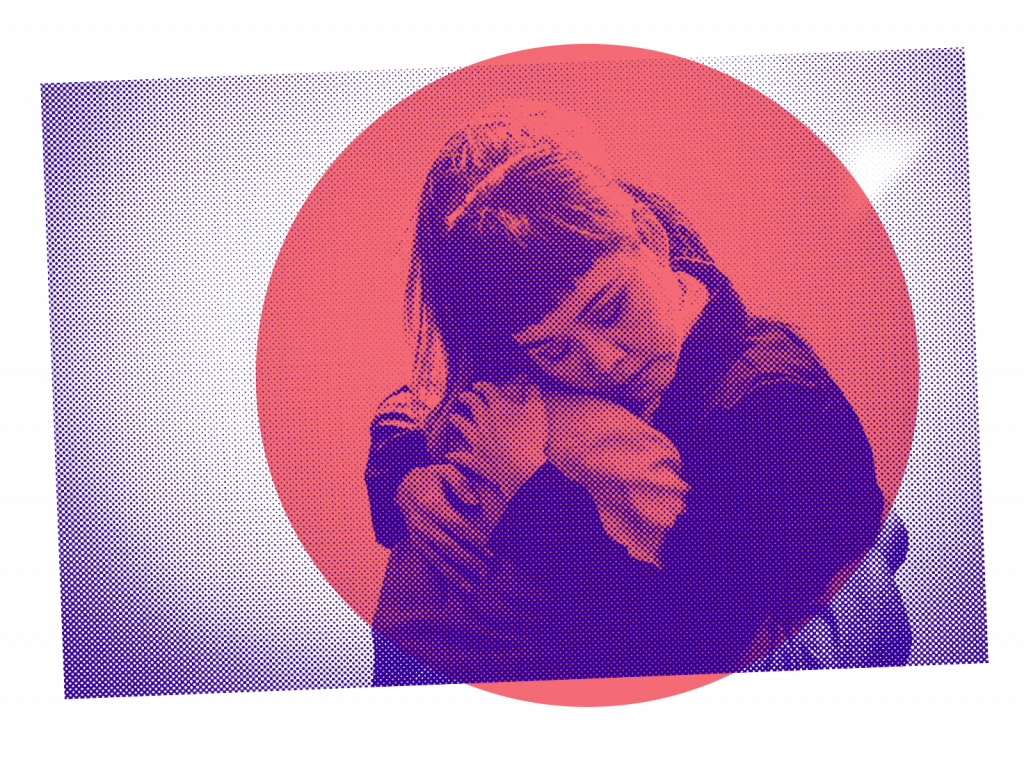 Two people, perhaps sisters, perhaps friends, embracing