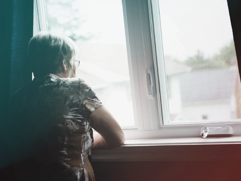 Older woman looking out the window