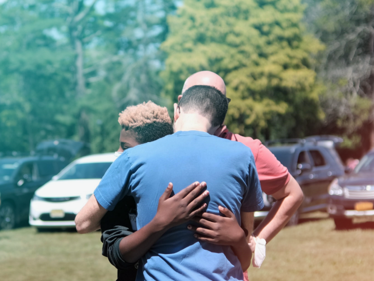 Ira hugging his son before drop-off at summer camp.