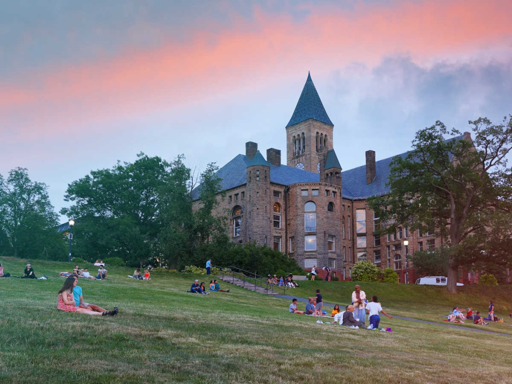 a castle and lawn with students at cornell